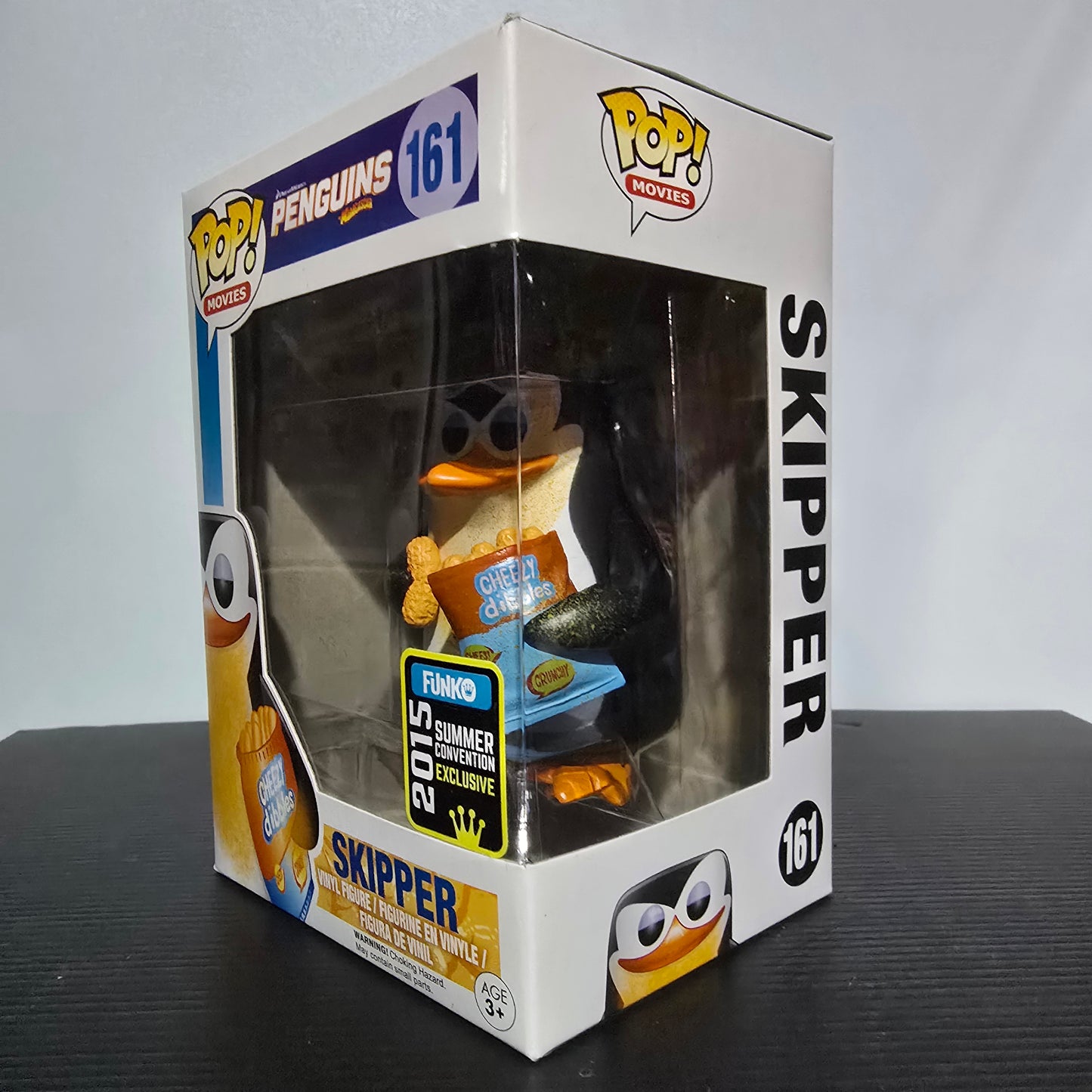 Funko Pop! Movies figure of Skipper from Penguins of Madagascar, specifically the #161 Skipper with Cheezy Dibbles variant, which was a 2015 Summer Convention