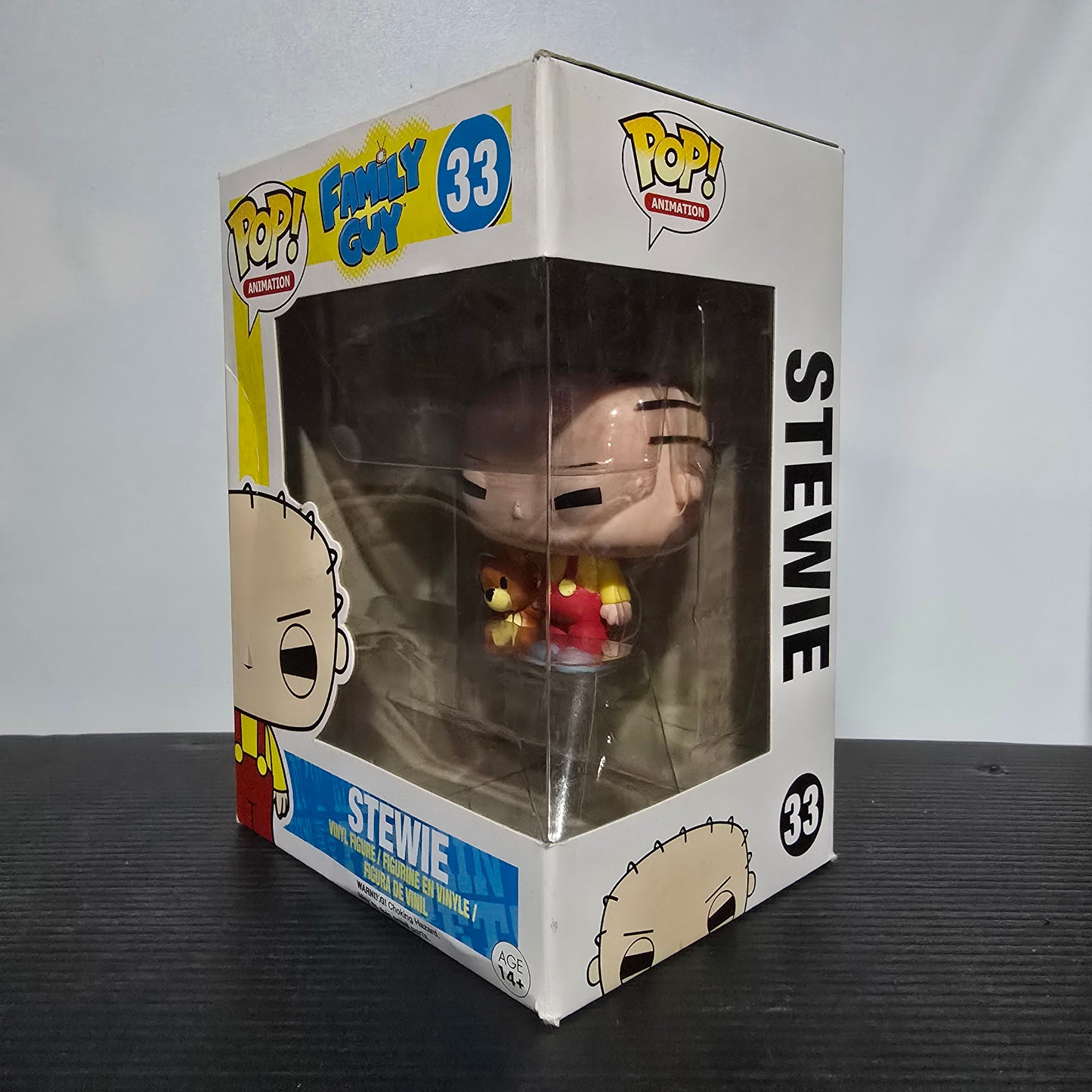 Funko Pop! Vinyl Figure of Stewie Griffin from the animated TV show Family Guy, specifically the #33 figure featuring Stewie with his teddy bear, Rupert.
