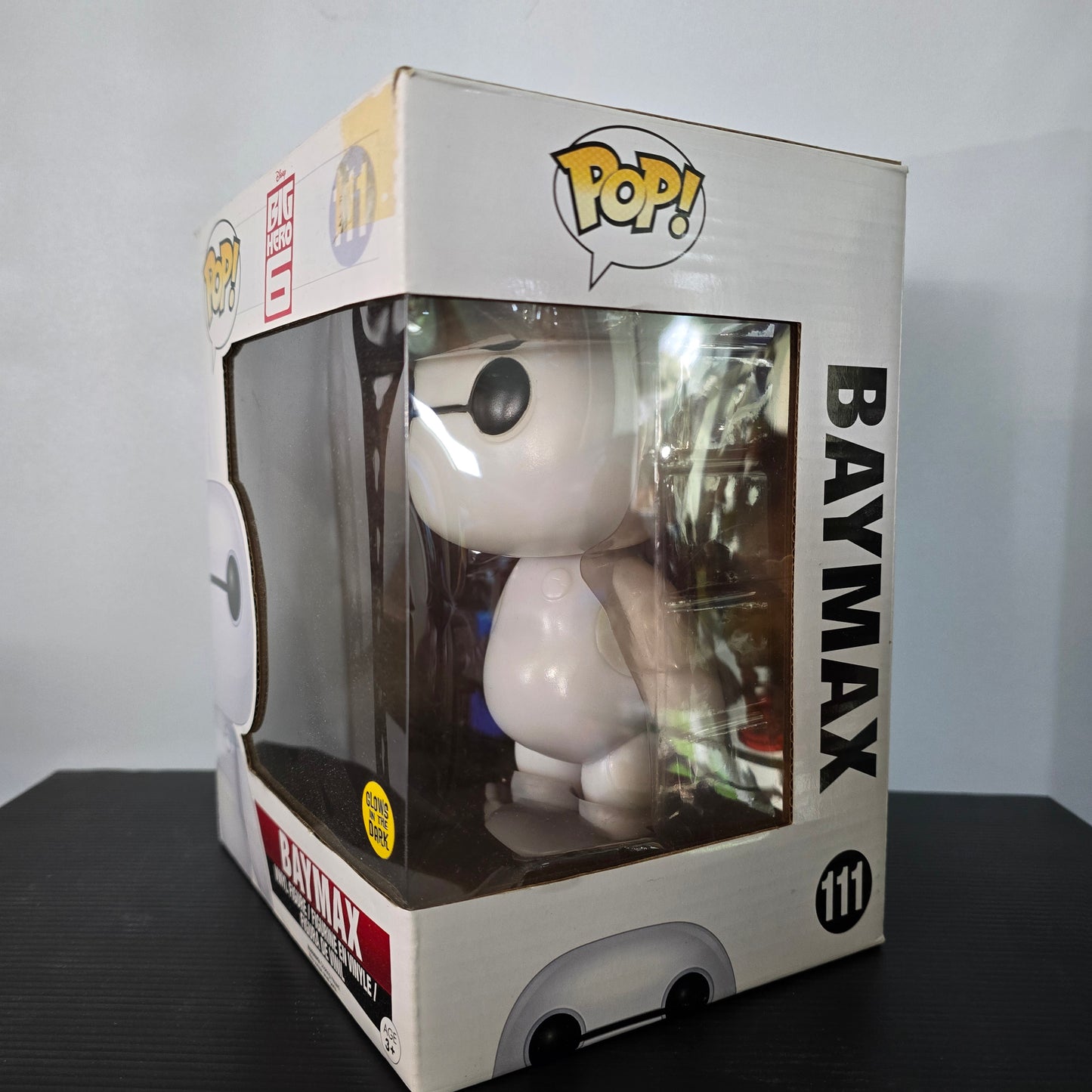 Funko Pop! Vinyl figure of Baymax from Disney's Big Hero 6, specifically the #111 Glow in the Dark (GITD) version.