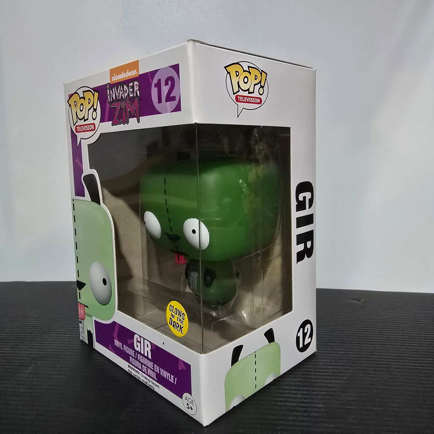 Funko Pop! Television vinyl figure of GIR from the show Invader Zim, specifically figure #12 which is a Hot Topic Exclusive Glow-in-the-Dark version.